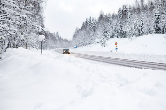 Vinterväg där bil kommer körande